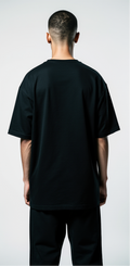 Studio fashion photography, male fashion model, oversized grey t-shirt, side-by-side view front and back. Front: glowing cybernetic eye dripping neon liquid. Back: graffiti text 