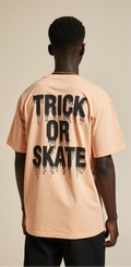 Trick or Skate Halloween T-Shirt | Oversized Streetwear Tee with Ghost Skateboard Graphic | Peach Unisex Cotton Top